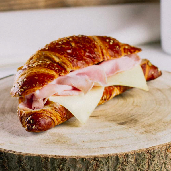 Laugenkorn Schinken-Käse ﻿Laugencroissant mit Leinsamen und Sesam. Belegt mit mildem, dänischen Käse und zartem Kochschinken.