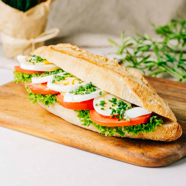 Küstenkruste Tomate-Ei ﻿Unser knuspriges Baguettebrötchen mit Tomate, Ei, hauseigener Remoulade und Lollo Bionda Salat.