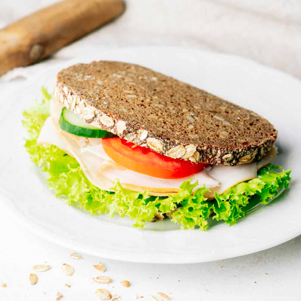 Klappstulle Pute ﻿Unser Hanseatenbrot Nr.1 mit saftiger Putenbrust, Joghurtrahmaufstrich mit Schnittlauch und Petersilie, Lollo Bionda, Tomate und Gurke.